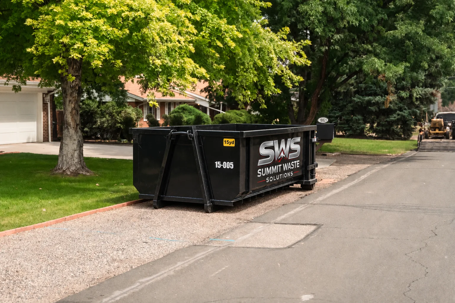 Black Summit Waste Solutions roll-off dumpster parked in a residential driveway